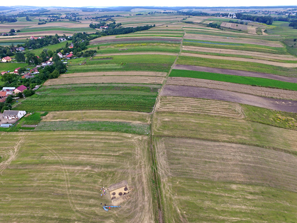 Aerial view of the excavation site and the agricultural landscape with a striped pattern of cultivated fields