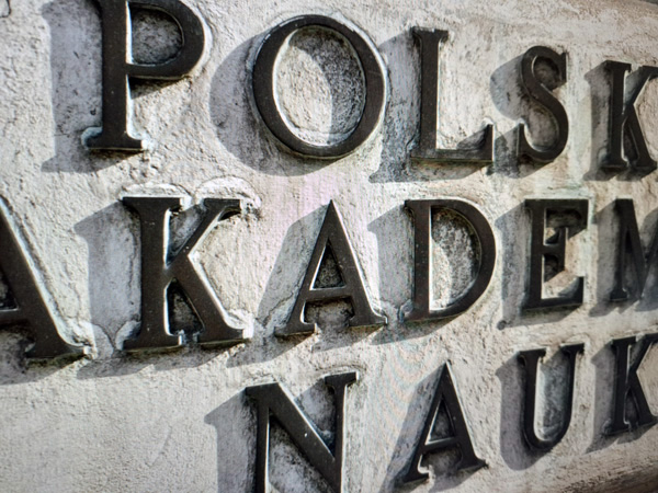 Close-up of the inscription in brass letters embedded in the wall: Polish Academy of Sciences